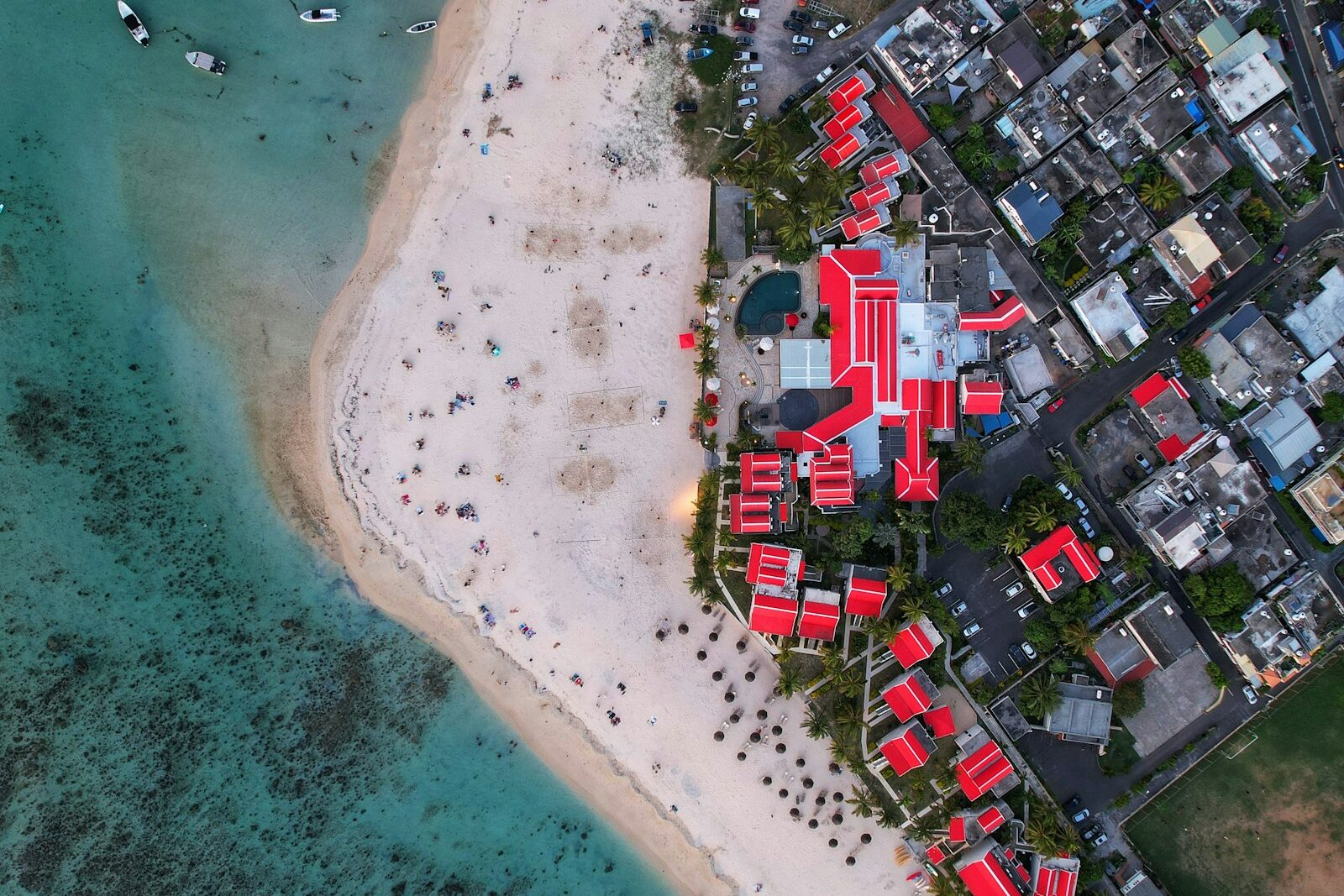 Aerial view of a coastal resort town beside a turquoise bay